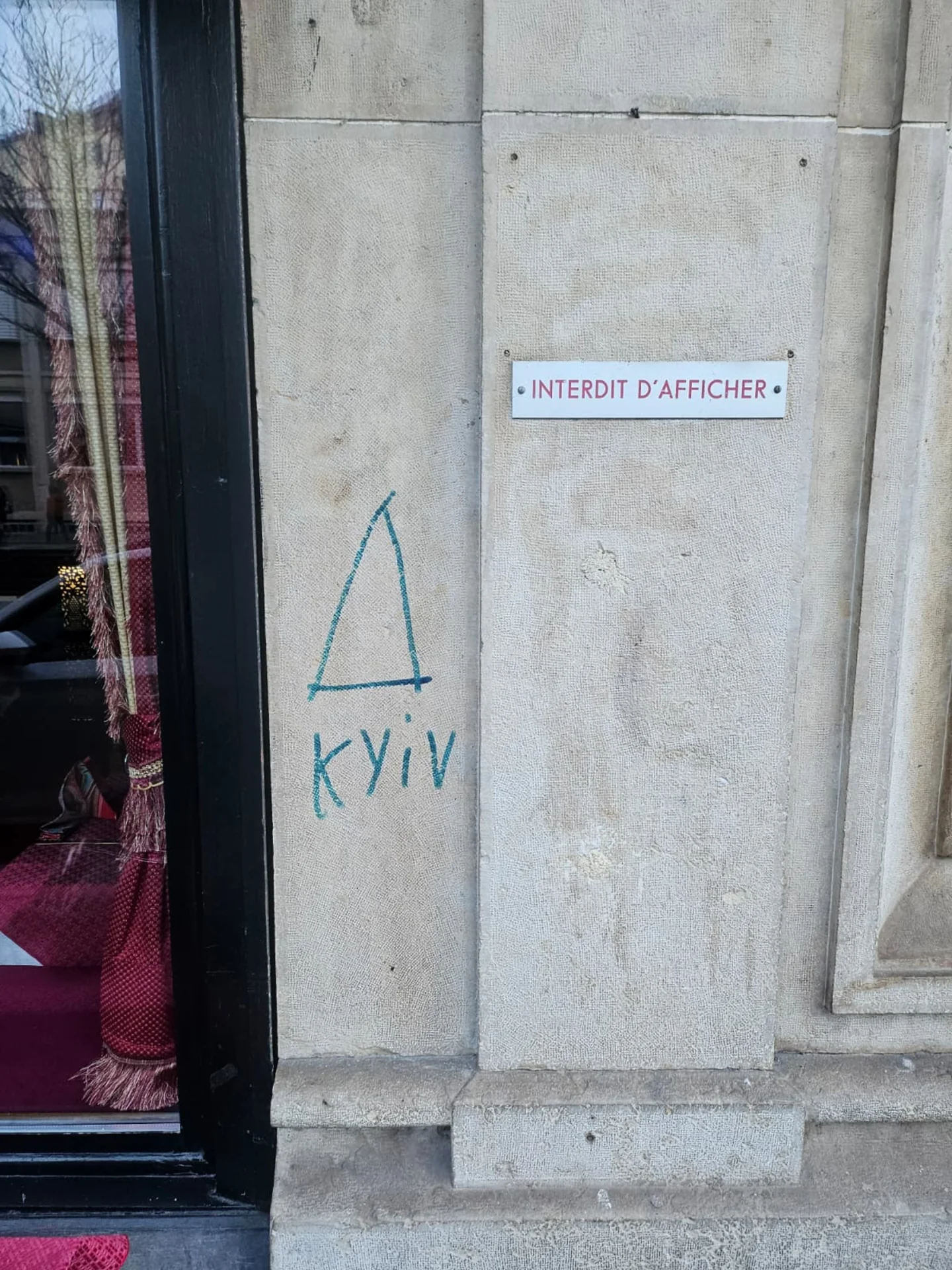 Graffiti sur une entrée en pierre avant intervention
